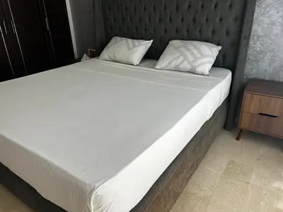 a large bed with white sheets and pillows on it at Modern Studio by the Beach of Casablanca Night Stay in Casablanca