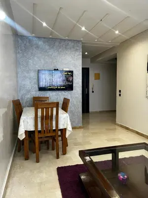 a dining room with a table and chairs and a painting at Modern Studio by the Beach of Casablanca Night Stay in Casablanca