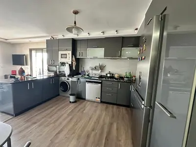 a kitchen with stainless steel appliances and wooden floors at Les jardins de cherrat in Bouznika