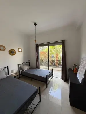 a bedroom with two beds and a large window at Appartement Moderne 2 chambres à Blanca Beach Sidi Rahal in Sidi Rahal