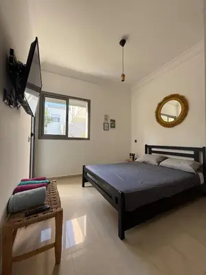 a bedroom with a large bed and a mirror at Appartement Moderne 2 chambres à Blanca Beach Sidi Rahal in Sidi Rahal