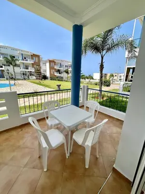 a white table and chairs on a balcony at Appartement à Sidi Rahal Piscine et Accès direct plage in Sidi Rahal