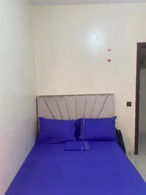 a bed with purple pillows in a small room at Comfort and Convenience in Casablanca