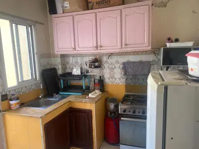 a kitchen with pink cabinets and a sink and a refrigerator at Comfort and Convenience in Casablanca