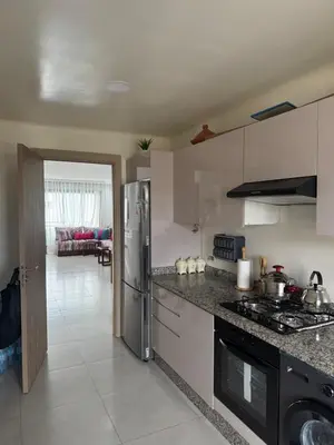 a kitchen with a refrigerator and a stove top oven at Blue dhalia beach a sidi rahal in Dar Oulad Hajj Kassem