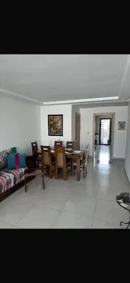 a living room with a couch and a table and chairs at Blue dhalia beach a sidi rahal in Dar Oulad Hajj Kassem