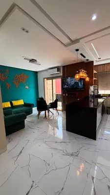 a living room with a green couch and a table at Studio lux in Bouznika