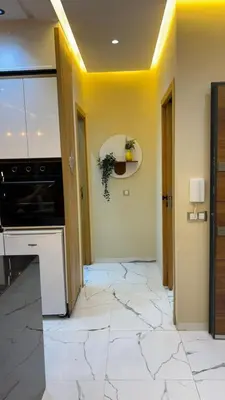 a kitchen with white tile floors and a stove at Studio lux in Bouznika