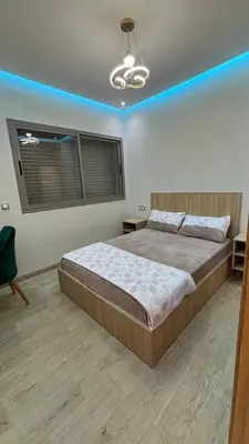 a bedroom with a large bed and a blue light at Studio lux in Bouznika