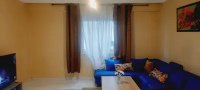 a living room with a blue couch and a window at Appartement Alhadika in Casablanca