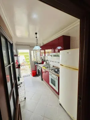 a kitchen with red cabinets and a white refrigerator at Loft12 in Rabat