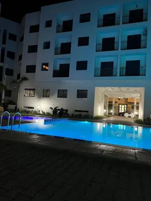 a swimming pool in front of a building at night at Dar laakbira in Bouznika