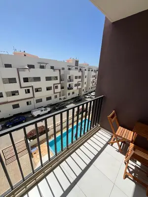 a balcony with a view of a pool and buildings at Dar laakbira in Bouznika