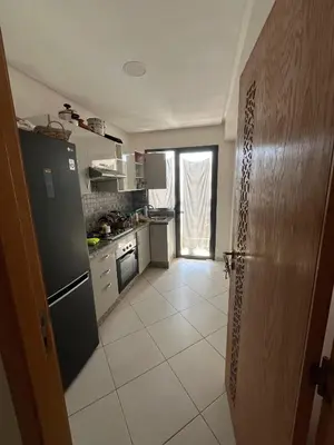 a kitchen with a refrigerator and a tile floor at Dar laakbira in Bouznika