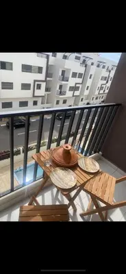 a hat and plates on a table on a balcony at Dar laakbira in Bouznika