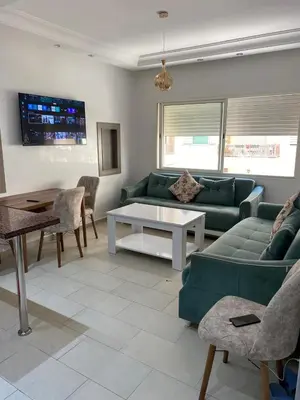 a living room with a green couch and a table at Cozy Relax in Mohammedia