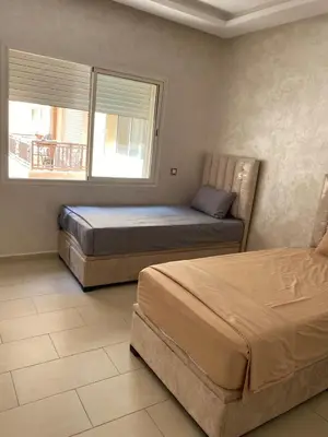 a bedroom with two beds and a window at Cozy Relax in Mohammedia