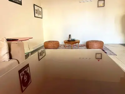 a living room with a table and two stools at Appartement Spacieux pour Famille Mâarif Casablanca in Maarif