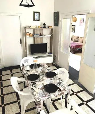 a dining room with a table and white chairs at Appartement Spacieux pour Famille Mâarif Casablanca in Maarif