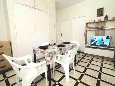 a dining room with a table and chairs and a tv at Appartement Spacieux pour Famille Mâarif Casablanca in Maarif