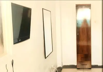 a living room with a tv and a mirror on a wall at Appartement Spacieux pour Famille Mâarif Casablanca in Maarif
