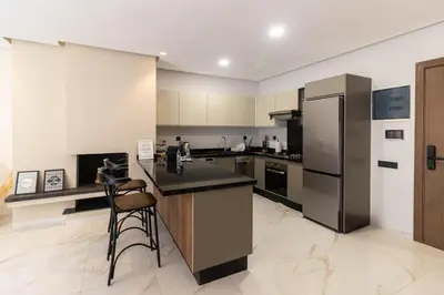 a large kitchen with a counter and a refrigerator at BRYJ 34 Luxury studio les princesses maarif in Casablanca