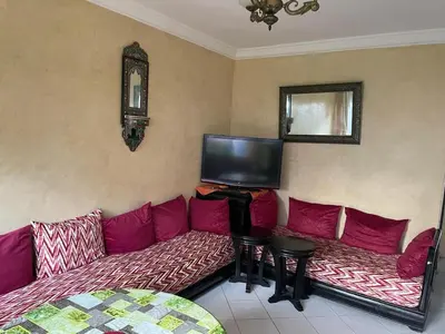 a living room with a red couch and a flat screen tv at Modern appartment in Casablanca