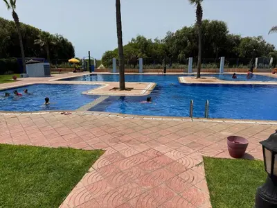 a pool with people swimming in the water at Modern appartment in Casablanca