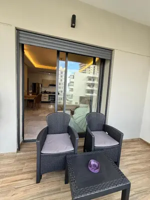 a living room with two chairs and a table at Cozy Studio Vue sur Piscine à Ocean Park Zenata City Eco in Aïn Harrouda