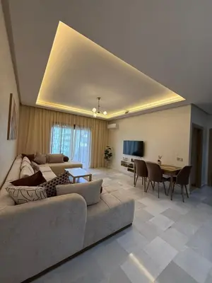 a living room with a couch and a table at Cozy Studio Vue sur Piscine à Ocean Park Zenata City Eco in Aïn Harrouda