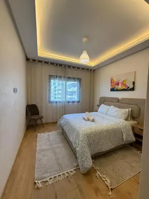 a bedroom with a large bed and a window at Cozy Studio Vue sur Piscine à Ocean Park Zenata City Eco in Aïn Harrouda