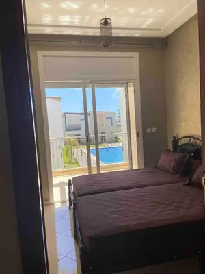 a bedroom with a bed and a large window at Ocean View Villa avec Piscine en Bord de Mer in Sidi Rahal