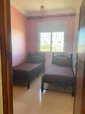 two beds in a room with a window at Ocean View Villa avec Piscine en Bord de Mer in Sidi Rahal