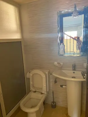a bathroom with a toilet and a sink and a mirror at Ocean View Villa avec Piscine en Bord de Mer in Sidi Rahal