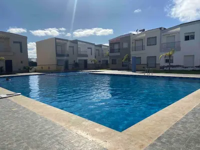 a swimming pool in front of some apartment buildings at Ocean View Villa avec Piscine en Bord de Mer in Sidi Rahal