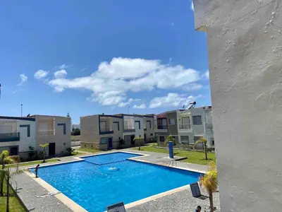 a swimming pool in front of some apartment buildings at Ocean View Villa avec Piscine en Bord de Mer in Sidi Rahal
