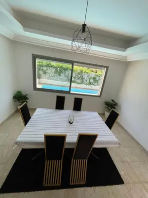 a dining room with a white table and chairs at Villa a darbouaza in Dar Bouazza