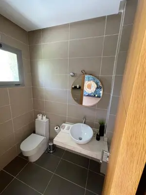 a bathroom with a sink and a toilet and a mirror at Villa a darbouaza in Dar Bouazza