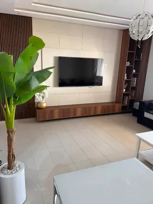 a living room with a tv and a plant at Luxury apartment in Mansouria in Mansouria