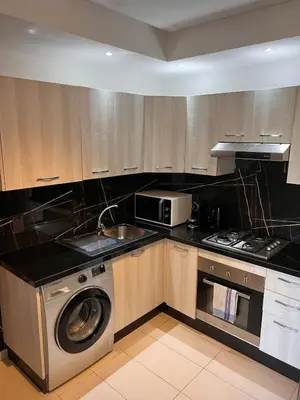 a kitchen with a washing machine and a microwave at Luxury apartment in Mansouria in Mansouria