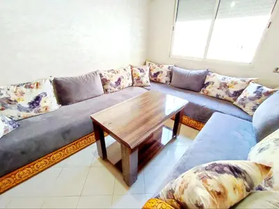 a living room with a couch and a wooden table at Comfortable Apartment Maârif Area in Casablanca