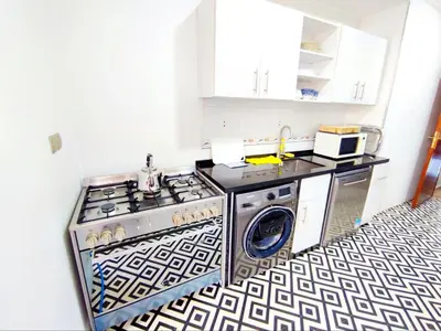 a kitchen with a stove and a washing machine at Comfortable Apartment Maârif Area in Casablanca