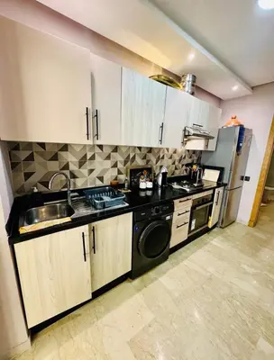 a kitchen with a sink and a dishwasher at Appartement Mer & Soleil à EL Mansoria in Pont Blondin