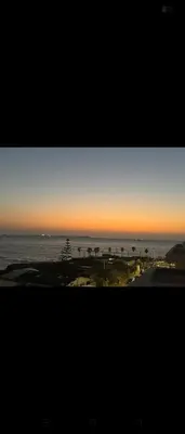 a view of the ocean at sunset from a building at Appartement Mer & Soleil à EL Mansoria in Pont Blondin