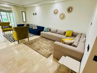 a living room with a couch and a table at Appartement Mer & Soleil à EL Mansoria in Pont Blondin