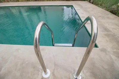 a swimming pool with a metal railing next to a pool at Appartement Neuf & Cosy avec vu sur mer -Zenata Eco City- in Aïn Harrouda