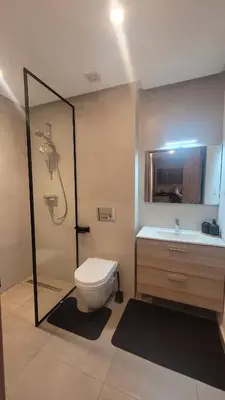 a bathroom with a toilet and a shower and a sink at Appartement Neuf & Cosy avec vu sur mer -Zenata Eco City- in Aïn Harrouda