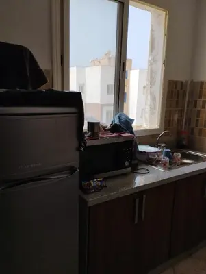 a kitchen with a counter with a sink and a window at Khalid in Bouznika