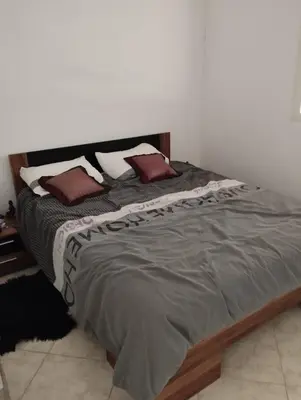 a bed with two pillows on it in a bedroom at Khalid in Bouznika