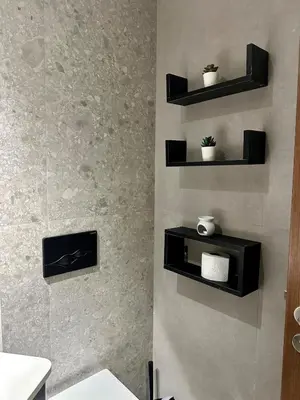 a bathroom with black shelves on the wall at Studio chic Palmier in Casablanca